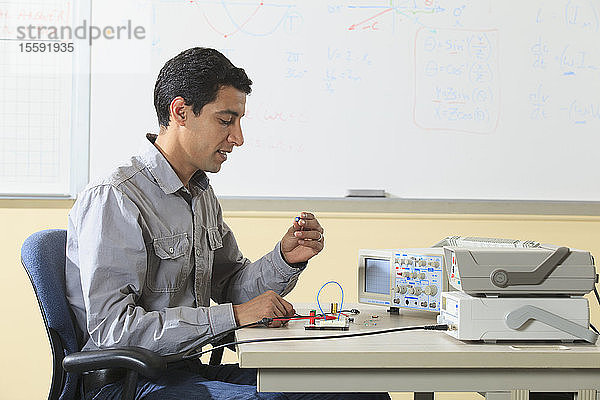 Ingenieurstudent bei der Vorbereitung eines Prototyping-Breadboards für ein Experiment im Elektroniklabor