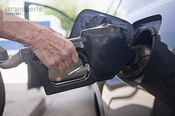 Frau tankt Auto an einer Tankstelle