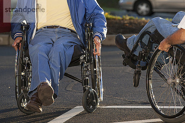 Mann mit Friedreich-Ataxie begrüßt seinen Freund mit Rückenmarksverletzung