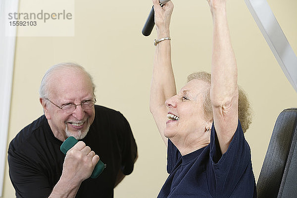 Ein älteres Paar trainiert im Fitnessstudio.