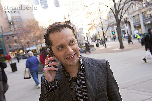 Geschäftsmann  der mit einem Mobiltelefon spricht
