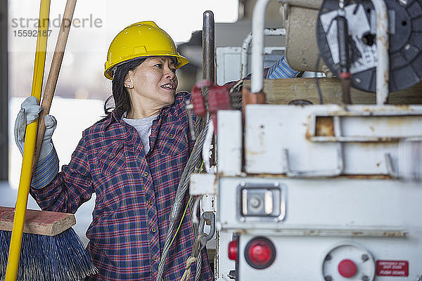 Weiblicher Energietechniker packt Werkzeuge in einen Kübelwagen