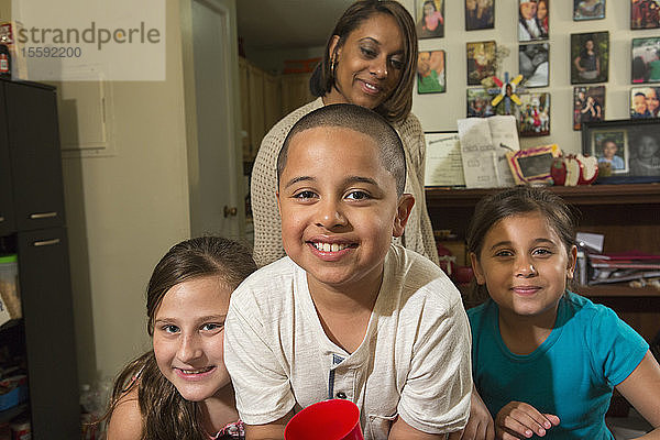 Hispanischer Junge mit Autismus mit seiner Mutter und seinen Schwestern zu Hause