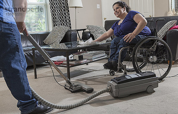 Frau mit Spina Bifida und ihr Mann putzen ihr Haus