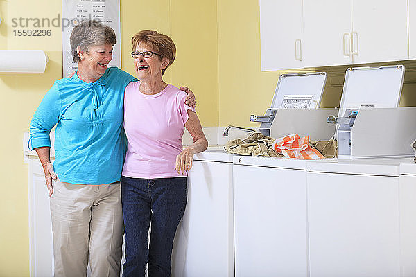 Lachende ältere Frauen in einer Waschküche