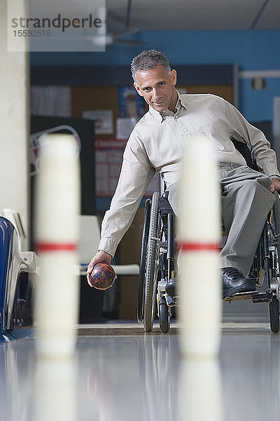Mann mit einer Rückenmarksverletzung spielt Bowling mit zehn Kegeln
