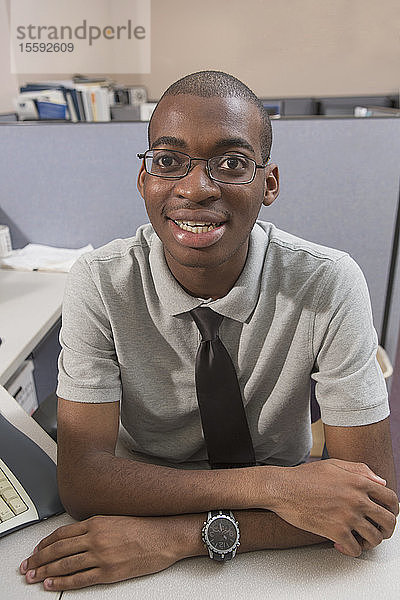 Porträt eines glücklichen afroamerikanischen Mannes mit Autismus  der in einem Büro arbeitet