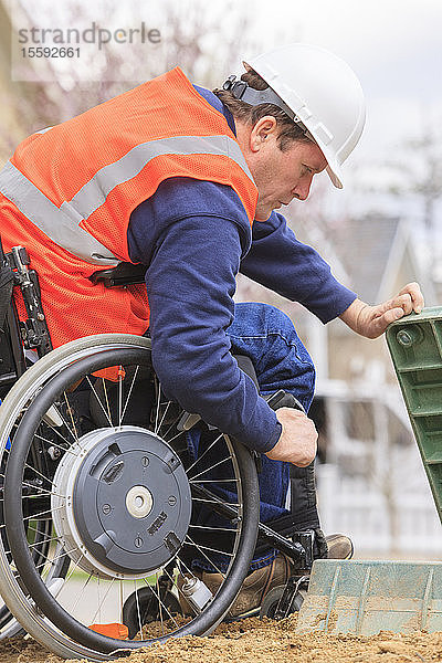 Bauingenieur mit Querschnittslähmung inspiziert Stromkasten