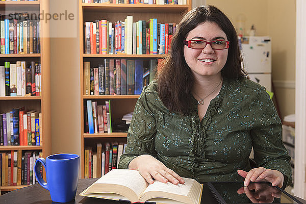 Frau mit Asperger-Syndrom entspannt sich mit einer Tasse Tee und einem Buch