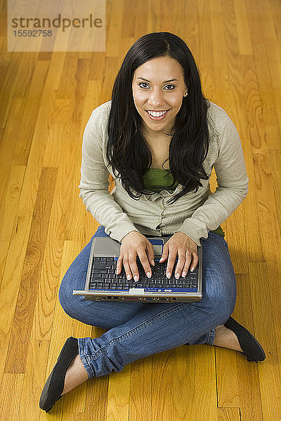 Hispanische Frau arbeitet an einem Laptop