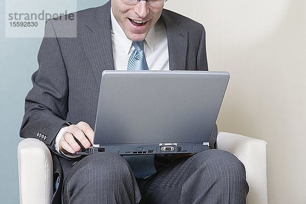 Blick auf einen Geschäftsmann  der an einem Laptop arbeitet.