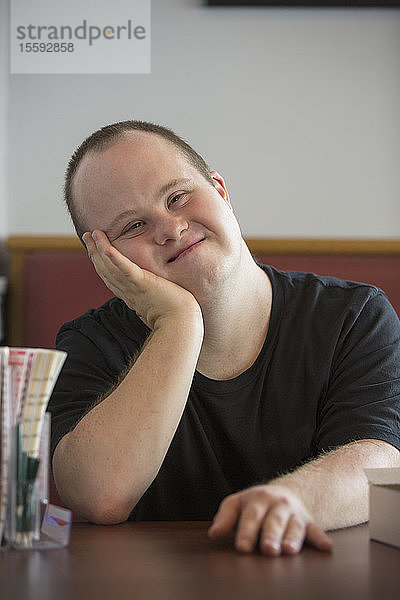 Porträt eines glücklichen Kellners mit Down-Syndrom in einem Restaurant