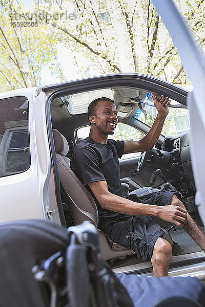 Mann mit Rückenmarkshautentzündung steigt in sein zugängliches Fahrzeug
