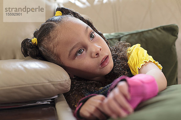 Kleines Mädchen mit zerebraler Lähmung sitzt zu Hause