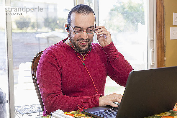 Mann mit Sehbehinderung hört Musik auf seinem Computer