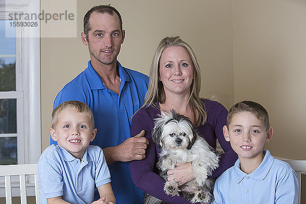 Porträt einer glücklichen Familie mit Hörbehinderung und einem Welpen