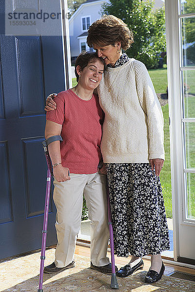 Frau mit zerebraler Lähmung und ihre Mutter vor der Tür