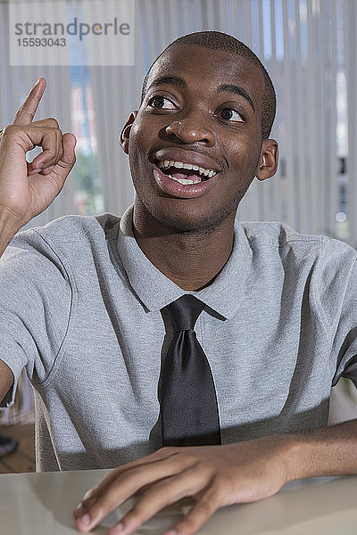 Glücklicher afroamerikanischer Mann mit Autismus bei der Arbeit in einem Büro