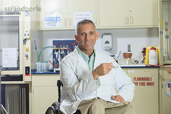Porträt eines lächelnden Professors mit einer Rückenmarksverletzung in einem Rollstuhl
