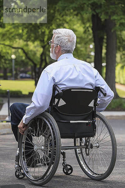 Geschäftsmann mit Muskeldystrophie in einem Rollstuhl