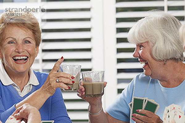 Ältere Frauen spielen Karten und genießen Tee