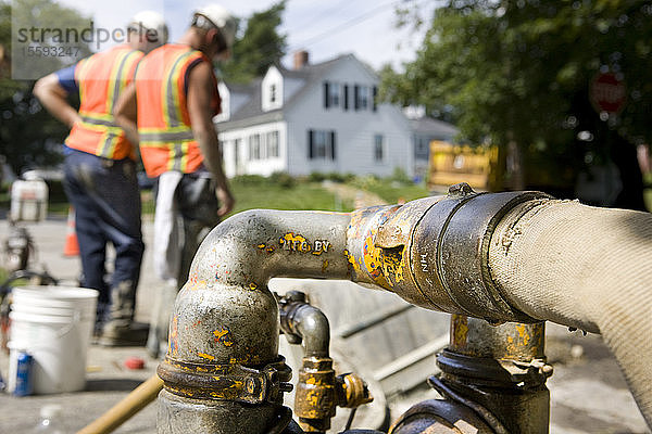 Wasserpumpe auf einer Baustelle  zwei Arbeiter im Hintergrund