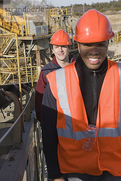 Zwei Ingenieure an einem Förderband auf einer Baustelle