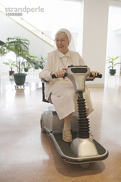 Nonne fährt einen motorisierten Rollstuhl