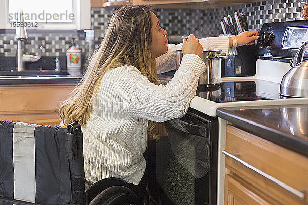 Frau mit Wirbelsäulenverletzung kocht