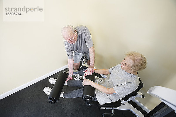 Ein älteres Paar trainiert im Fitnessstudio.