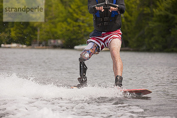 Sportler mit Beinprothese beim Wasserski