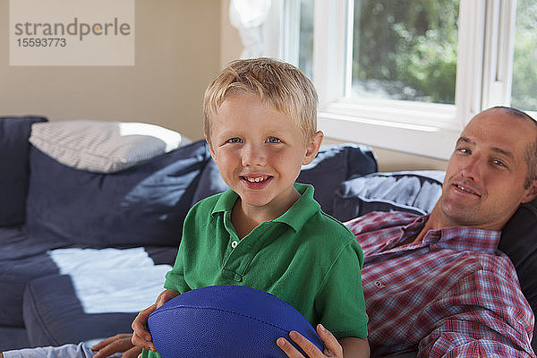 Vater und Sohn mit Hörbehinderung entspannen sich auf der Couch