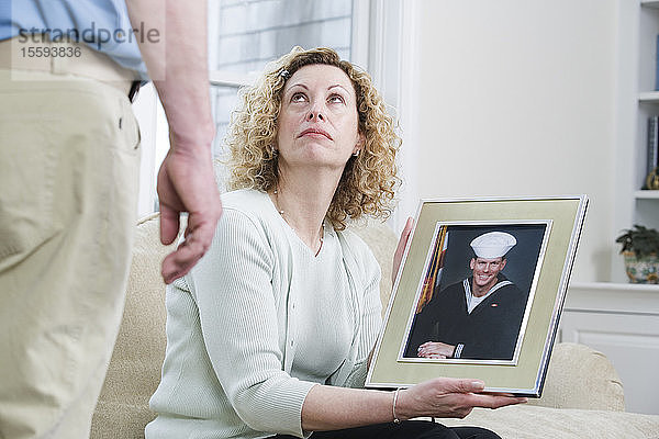 Frau zeigt Bild ihres Sohnes  der beim Militär arbeitet