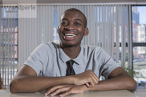Porträt eines glücklichen afroamerikanischen Mannes mit Autismus  der in einem Büro arbeitet