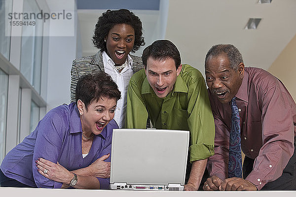 Geschäftsleute  die einen Laptop benutzen und lächeln