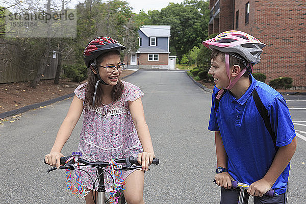 Ein lernbehindertes Mädchen fährt mit ihrem Bruder Fahrrad