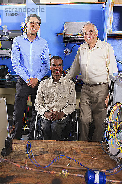 Ausbilder und zwei Schüler im Unterrichtsraum für HLK und Prozesssteuerung ein Schüler im Rollstuhl