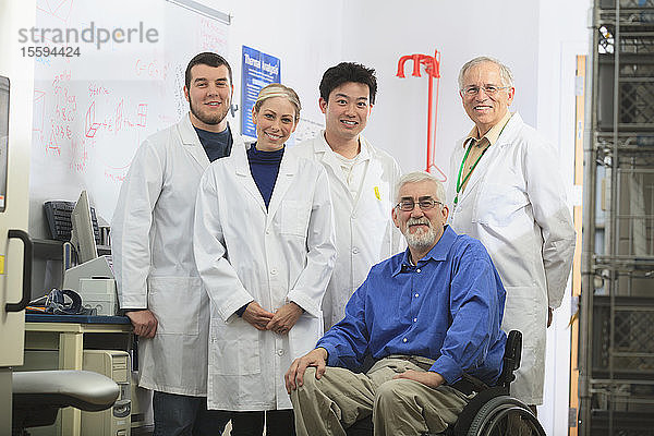 Ingenieurprofessoren  einer mit Muskeldystrophie  und Studenten im chemischen Analyselabor