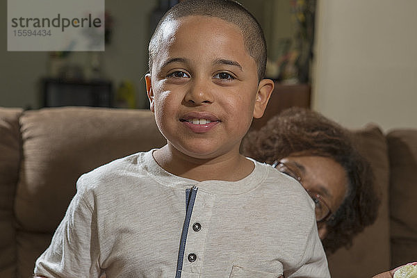 Hispanischer Junge mit Autismus sitzt mit seiner Großmutter zu Hause