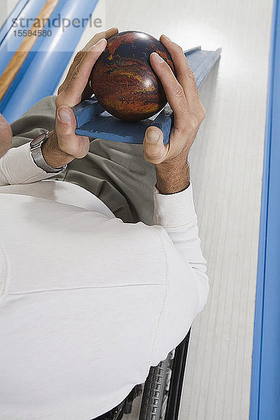 Hochformatige Ansicht eines Mannes mit einer Rückenmarksverletzung beim Bowling