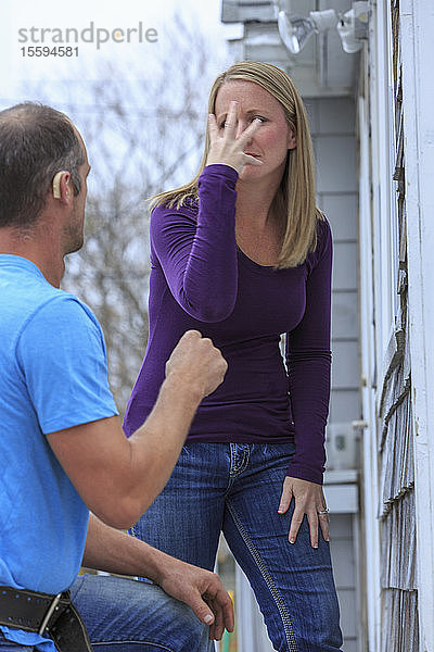 Ein Hausbesitzer kommuniziert mit einem Handwerker in amerikanischer Zeichensprache und sagt Schön und Ja .