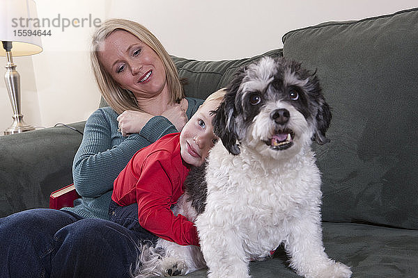 Frau  die das Wort Liebe in amerikanischer Zeichensprache gebärdet  während ihr Sohn einen Hund umarmt