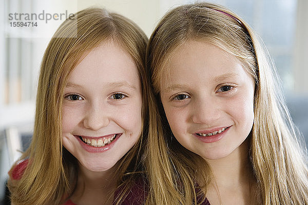 Porträt von zwei lächelnden Schwestern.