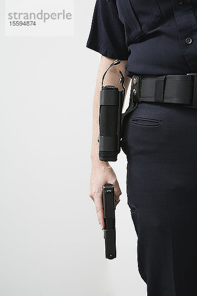 Eine Polizistin hält eine geladene  schussbereite Pistole.