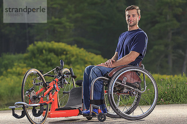 Ein querschnittsgelähmter Mann in seinem Rollstuhl mit seinem speziell angefertigten adaptiven Handbike