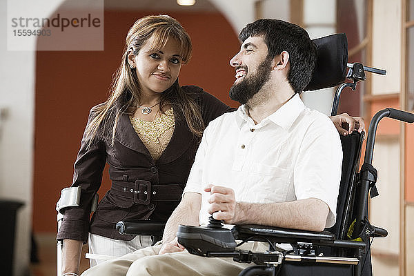 Porträt eines Mannes mit zerebraler Lähmung und einer lächelnden Frau.