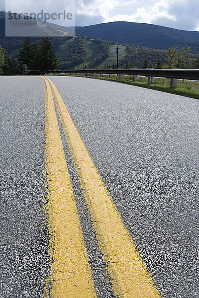 Nahaufnahme von gelben Trennlinien auf einer Autobahn.