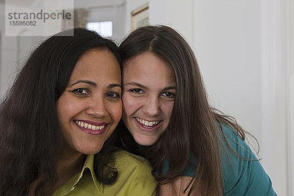 Hispanische Frau lächelt mit ihrer Tochter im Teenageralter