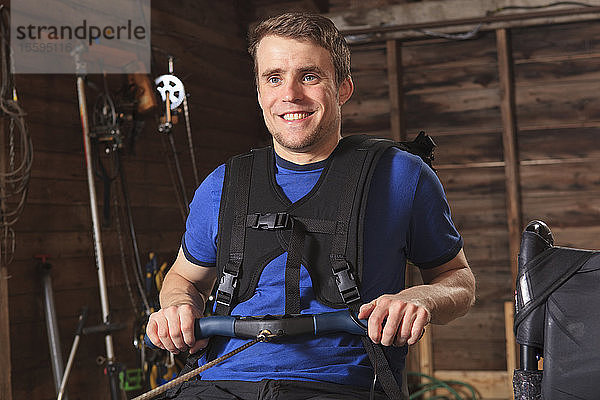 Mann mit Rückenmarksverletzung benutzt sein Rudergerät