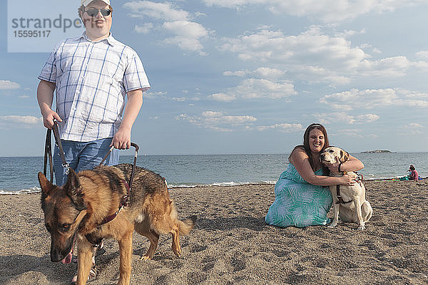 Ein blindes Paar vergnügt sich am Strand mit seinen Diensthunden